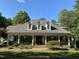 Inviting home with a brick walkway, classic front porch with rocking chairs, and lush landscaping at 106 Woodkirk Ln, Chapel Hill, NC 27514
