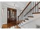 Elegant foyer with hardwood floors, a staircase with iron railing, and a glass-paneled front door at 106 Woodkirk Ln, Chapel Hill, NC 27514