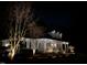 Night view of a charming home featuring beautiful landscaping, a cozy porch, and warm exterior lighting at 106 Woodkirk Ln, Chapel Hill, NC 27514