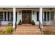Classic front porch with brick steps, rocking chairs, and a welcoming entryway with sidelights at 106 Woodkirk Ln, Chapel Hill, NC 27514