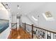 Hallway featuring hardwood floors, wrought iron handrail and skylights for natural light at 106 Woodkirk Ln, Chapel Hill, NC 27514