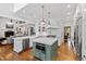Bright, modern kitchen with white cabinets, a subway tile backsplash, and a green kitchen island with white countertop at 106 Woodkirk Ln, Chapel Hill, NC 27514