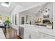 Bright, modern kitchen featuring an island with marble countertop, a stainless steel dishwasher, and a ceramic farmhouse sink at 106 Woodkirk Ln, Chapel Hill, NC 27514