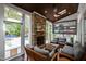 Inviting sunroom with a stacked stone fireplace, comfortable seating, and an outdoor pool at 106 Woodkirk Ln, Chapel Hill, NC 27514