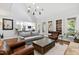 Bright living room with hardwood floors, stone fireplace, and large windows showcasing natural light at 106 Woodkirk Ln, Chapel Hill, NC 27514