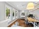 Bright office with modern desk, white walls, hardwood floors, and views of the pool and backyard through large windows at 106 Woodkirk Ln, Chapel Hill, NC 27514