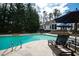 Inviting poolside with lounge chairs for sunbathing, surrounded by lush trees to provide shady relaxation at 106 Woodkirk Ln, Chapel Hill, NC 27514