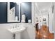 Charming powder room with navy blue walls, white wainscoting, pedestal sink, and hardwood floors at 106 Woodkirk Ln, Chapel Hill, NC 27514