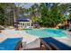 A picturesque pool area with a cabana, lush greenery, and a rock waterfall slide for Gathering fun at 106 Woodkirk Ln, Chapel Hill, NC 27514