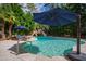 Inviting pool area with relaxing lounge chairs, rock waterfall, and a sunshade for ultimate outdoor enjoyment at 106 Woodkirk Ln, Chapel Hill, NC 27514