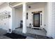 Inviting front porch with classic columns, a black front door, and a cozy seating area with a rocking chair at 1213 Valley Dale Dr, Fuquay Varina, NC 27526