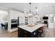 Modern kitchen with a dark island and quartz countertop, stainless appliances, and views of dining and living areas at 1213 Valley Dale Dr, Fuquay Varina, NC 27526
