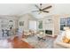 Open-concept living room featuring a fireplace, ceiling fan and lots of natural light at 1221 Renshaw Ct, Cary, NC 27518