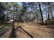 A large backyard surrounded by lots of trees with a playground at 1501 Ramson Ct, Raleigh, NC 27603