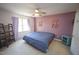 Bedroom with carpet, blue bedding, ceiling fan, purple accent wall, and natural light at 1501 Ramson Ct, Raleigh, NC 27603
