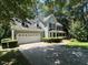 Inviting two-story home showcasing a front-facing two car garage, lush landscaping, and mature trees at 1501 Ramson Ct, Raleigh, NC 27603