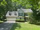 Charming two-story home with light blue siding, complemented by a lush green lawn and mature trees at 1501 Ramson Ct, Raleigh, NC 27603