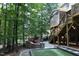 Backyard featuring a stone fire pit, artificial turf, steps to the screened-in porch, and lush landscaping at 156 Stoney Creek Way, Chapel Hill, NC 27517