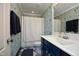 Bathroom featuring wallpaper, blue vanity and tub with shower at 156 Stoney Creek Way, Chapel Hill, NC 27517