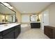 Bathroom featuring double vanities, tile floors, and tiled corner tub beneath a window at 156 Stoney Creek Way, Chapel Hill, NC 27517