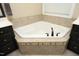 Close up of bathroom featuring a corner tub with decorative tile surround and brushed bronze faucet at 156 Stoney Creek Way, Chapel Hill, NC 27517