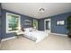 Blue bedroom with large windows, a bed, and neutral carpet, offering a bright and inviting space at 156 Stoney Creek Way, Chapel Hill, NC 27517