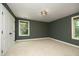 Empty bedroom with carpet, two windows, green walls, and a double door, perfect for customization at 156 Stoney Creek Way, Chapel Hill, NC 27517