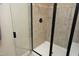 Glass shower enclosure features neutral colored tile and modern dark fixtures at 156 Stoney Creek Way, Chapel Hill, NC 27517