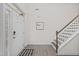 Bright entryway featuring hardwood floors, a staircase with white risers, and a charming 'Home' sign at 190 Hickory Run Ln, Franklinton, NC 27525