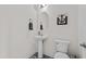 Stylish powder room featuring a pedestal sink, oval mirror, and a modern toilet with a dark accent at 190 Hickory Run Ln, Franklinton, NC 27525