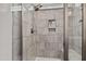 Tiled shower with shower head and built-in shelves for bath products, adding convenience and style at 190 Hickory Run Ln, Franklinton, NC 27525