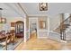 Elegant foyer featuring hardwood floors, staircase, mirror, and dining room with china cabinet at 200 Parkbranch Ln, Cary, NC 27519