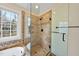Modern glass-enclosed shower with a tiled surround and natural light from the window at 200 Parkbranch Ln, Cary, NC 27519