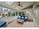 Relaxing sunroom with a comfortable blue sofa, skylights, and views of the surrounding greenery at 200 Parkbranch Ln, Cary, NC 27519
