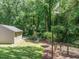 A verdant backyard includes a basketball hoop and leads to mature trees and plenty of shade at 2001 Manuel St, Raleigh, NC 27612