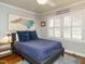 Bedroom features a full bed with blue bedding and decorative pillows, hardwood floors, and white shutters at 2001 Manuel St, Raleigh, NC 27612
