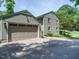 A gray brick house with an attached garage features a paved driveway and landscaped yard at 2001 Manuel St, Raleigh, NC 27612