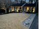 The front of a home at dusk is illuminated by landscape lighting, with a paver walkway at 2001 Manuel St, Raleigh, NC 27612