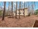 Backyard view highlighting the home's exterior amidst the privacy of mature trees at 203 Lexington Rd, Chapel Hill, NC 27516