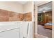 Bathroom with a walk-in tub, tiled walls, and a doorway leading to a bedroom with wood paneling at 203 Lexington Rd, Chapel Hill, NC 27516