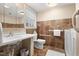 Well-lit bathroom with a sink, toilet, grab bars, accessible shower, and neutral-toned tiles at 203 Lexington Rd, Chapel Hill, NC 27516
