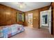 Bedroom with wood paneled walls, carpet, a ceiling fan, and an ensuite bathroom at 203 Lexington Rd, Chapel Hill, NC 27516