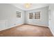 Spacious bedroom with a ceiling fan, large windows and tan carpet at 203 Lexington Rd, Chapel Hill, NC 27516