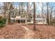 Inviting two-story home with brick accents, green shutters, and a walkway through the trees at 203 Lexington Rd, Chapel Hill, NC 27516