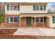 Charming front exterior with a covered porch, brick accents, and freshly landscaped garden beds at 203 Lexington Rd, Chapel Hill, NC 27516