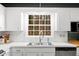 Bright kitchen sink featuring a large window, white cabinets, and stainless steel appliances at 203 Lexington Rd, Chapel Hill, NC 27516