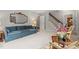 Spacious living room with a blue sofa, elegant mirror, plush carpet, and staircase leading to the upper level at 203 Lexington Rd, Chapel Hill, NC 27516