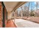 Covered porch with a tile floor and view of the tree filled front yard at 203 Lexington Rd, Chapel Hill, NC 27516