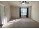 Spacious bedroom with a ceiling fan, neutral carpet, and a window letting in natural light at 21 Suncrest Ct, Durham, NC 27703
