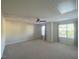 Spacious bedroom featuring neutral carpet and walls, ceiling fan, and natural light from the multiple windows at 21 Suncrest Ct, Durham, NC 27703